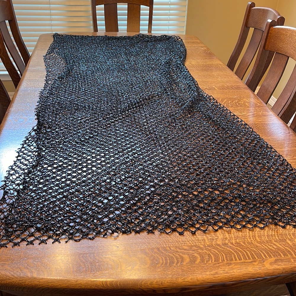77”x66” Halloween style cobweb fabric in black sparkly material.